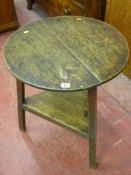 A 19th Century oak cricket table, the 54.5 cms diameter top on chamfered legs with triangular