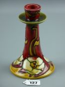 A Minton Secessionist single candlestick having a stylized tube lined floral pattern by designers