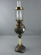 A Victorian cast metal oil lamp with onyx column, the base with winged cherub head decoration,