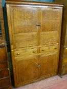 An early 19th Century one piece oak and pine sided press cupboard with twin applied panel upper