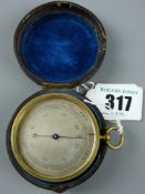 A 19th Century pocket barometer in a gilt brass case and revolving bezel and silvered dial, the rear