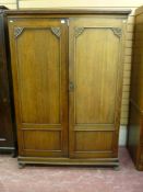 A 20th Century oak two door compactum style wardrobe with fitted interior, trademarked 'The