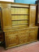 A George III oak dresser with inverted moulded crown and frieze, three shelf wide boarded back and
