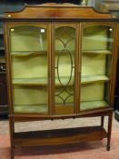 An Edwardian crossbanded mahogany two door display cabinet with centre glazed panel and shaped
