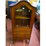 An Edwardian inlaid mahogany dome topped cabinet with bevelled glass door and interior shelf over