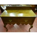 A 20th Century oak two drawer lowboy with railback, shaped front apron on Queen Anne front supports,