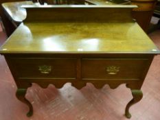 A 20th Century oak two drawer lowboy with railback, shaped front apron on Queen Anne front supports,