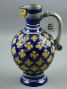 A Mintons Majolica Bellarmine style mask jug, cobalt ground with yellow embossed flowers and mask
