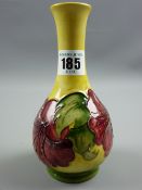 A Moorcroft Hibiscus narrow necked vase on a green and yellow ground, 16 cms high (crazing and
