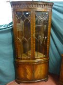 A quality reproduction mahogany double door corner cabinet with arched gallery top frieze, ten
