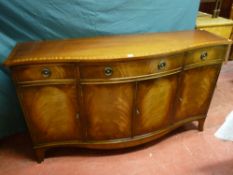 A reproduction crossbanded mahogany serpentine front sideboard, three frieze drawers with ring