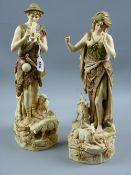 A pair of Royal Dux figures of shepherd and shepherdess, the man playing pan pipes with sheep at his