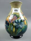 A Moorcroft Spring Flowers tonal green ground baluster vase, 18.5 cms high, underglazed blue