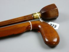 A mahogany blade edged walking cane with golf club head grip and another wooden shafted walking cane