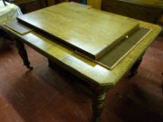 A circa 1900 oak extending dining table with canted corners and two extra leaves on block and turned