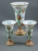 A three piece glass vase garniture of one large and two small trumpet vases with all over hand