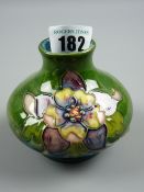 A Moorcroft Columbine green ground small squat vase, Moorcroft paper label to the base 'Potters to