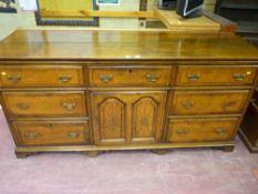 A George III oak dresser base, the twin plank moulded top over an arrangement of seven drawers