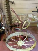 An antique Deering Ideal sickle bar harvester with iron spoke wheels and seat, 130 cms wide, 115 cms