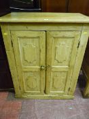 A stripped pine two door cupboard with raised panel doors and interior shelving, 98 x 80 cms