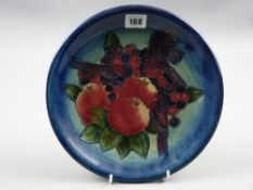 A 26 cms diameter Moorcroft Finches plate with tube lined bird and fruit decoration on a deep blue