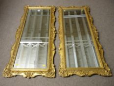 A pair of late 19th/early 20th Century gilt mirrors, carved pine with bole and gilt decorated gesso,