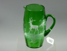 An antique green glass jug with Mary Gregory style decoration of a stag in woodland, the jug with
