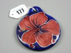 A Moorcroft Hibiscus unusual pottery wall disc with pierced hanging hole, single colour hibiscus