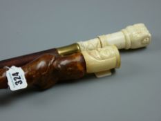 A carved bone handled walking cane in the form of a hand gripping a snake with rope pattern base,