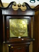 An 18th Century oak longcase clock, the square hood having a scrolled pediment with brass finials,