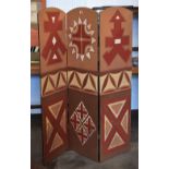 A three fold studded arched top dressing screen with silk applique covering of Aztec influence in