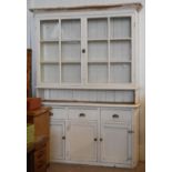 A large white painted dresser, the base with three cupboards below three equal upper drawers and