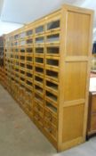 A bank of four haberdashery cabinets, each composed of two base drawers and sixteen pull out glass