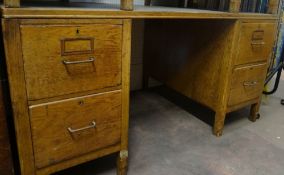 A larger vintage office desk with two flanks of two deep drawers with metal handles