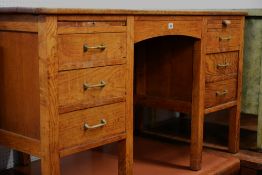 A vintage oak kneehole desk with two banks of three drawers