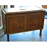 An unusual panelled oak blanket chest raised on four corner supports and with raised diamond