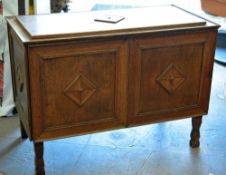 An unusual panelled oak blanket chest raised on four corner supports and with raised diamond