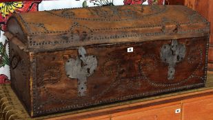 An antique dome studded leather trunk with large metal work escutcheons and having a floral fabric