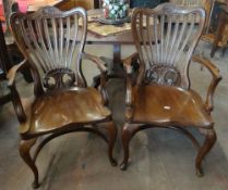 A pair of continental elbow chairs elaborately carved with splat backs and on cabriole front