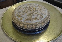 An ebonised tapestry topped circular fotstool and a large brass Benares tea table top