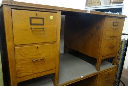 A vintage kneehole desk, each flank with two deep drawers and metal handles