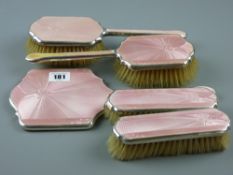 A five piece silver and pink enamel Art Deco dressing table set, Birmingham 1936 with engine