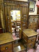 A 20th Century Gothic oak style bedroom suite of two door wardrobe and tallboy, long mirrored