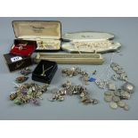 A parcel of mixed jewellery including silver charm bracelets, a yellow metal bar brooch with
