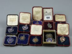 Twelve silver mainly cross country and athletics related trophy pendants in their boxes, majority