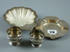 Four hallmarked silver items to include a shell shaped dish with glass liner, a circular ashtray and