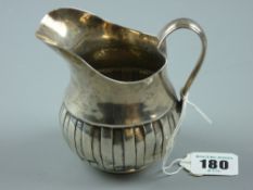 A Dublin hallmarked silver cream jug with wide flared spout and bulbous base with segmented bands,