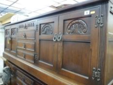 A reproduction Priory style sideboard with four central drawers and flanking twin door cupboards