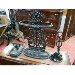 A cast iron black painted oval stickstand, a black painted cast iron doorstop with lion base and a