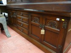 A reproduction Priory style sideboard with four central drawers and flanking twin door cupboards
